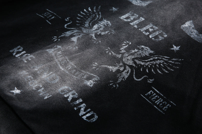 Close-up of back graphic on washed black hoodie with eagle and Rise and Grind text