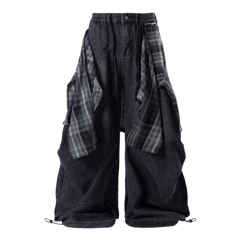 Black wide-leg layered plaid jeans with draped plaid side panels and a visible waistband zipper