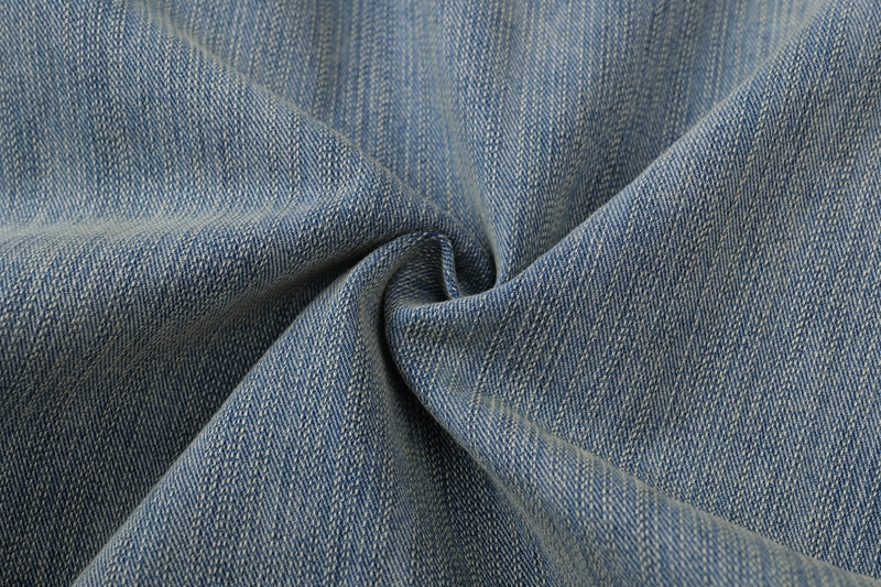 Close-up of blue denim fabric texture with faded vintage wash and twill weave