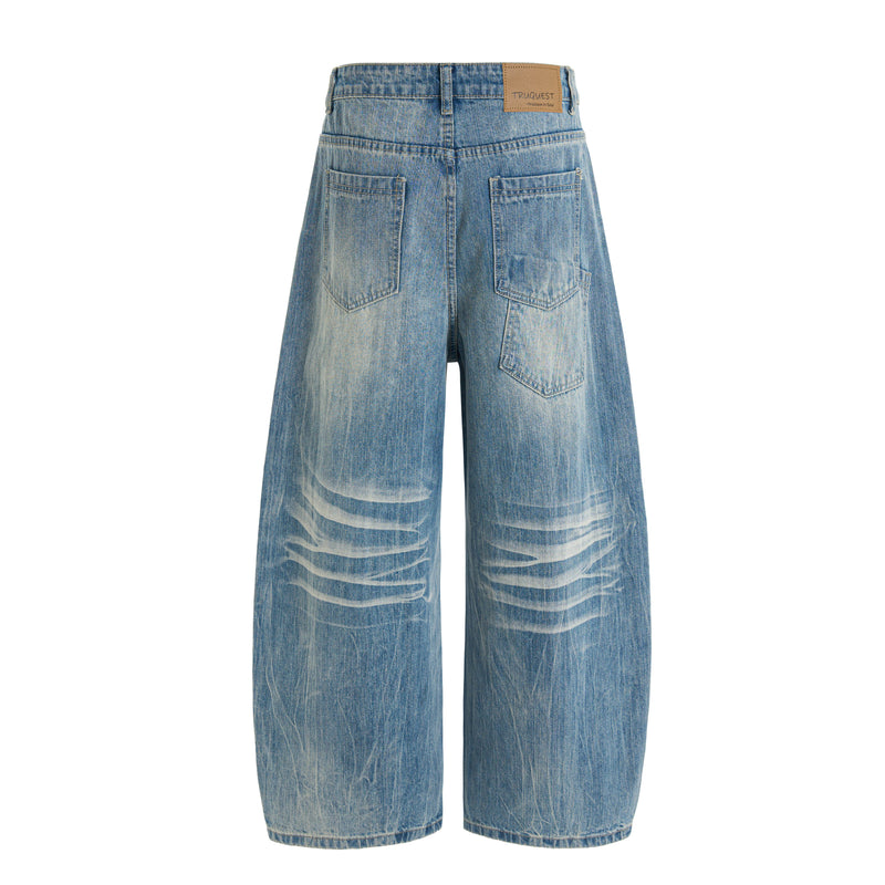 Back view of blue wide-leg denim jeans with faded wash, patch label, and four-pocket styling