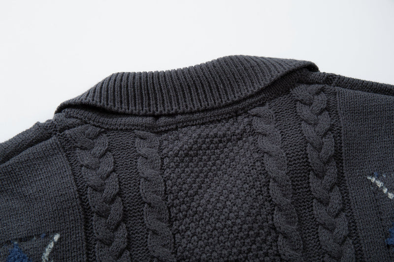 Close-up of dark cable knit collar and shoulder with textured knit detail