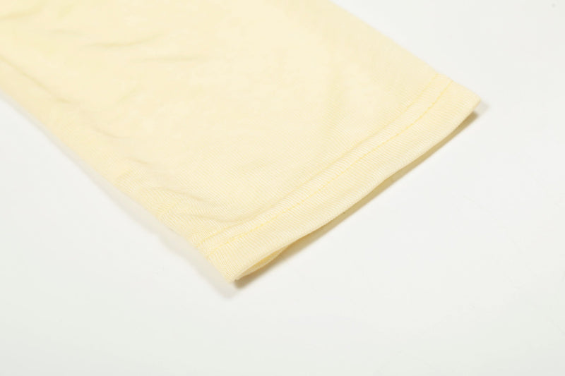 Close-up of light yellow sleeve cuff with fine knit fabric and stitching