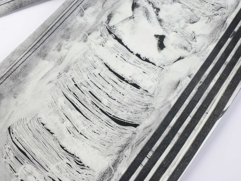 Close-up of front leg on ripped denim jeans with frayed distressing and black side stripes
