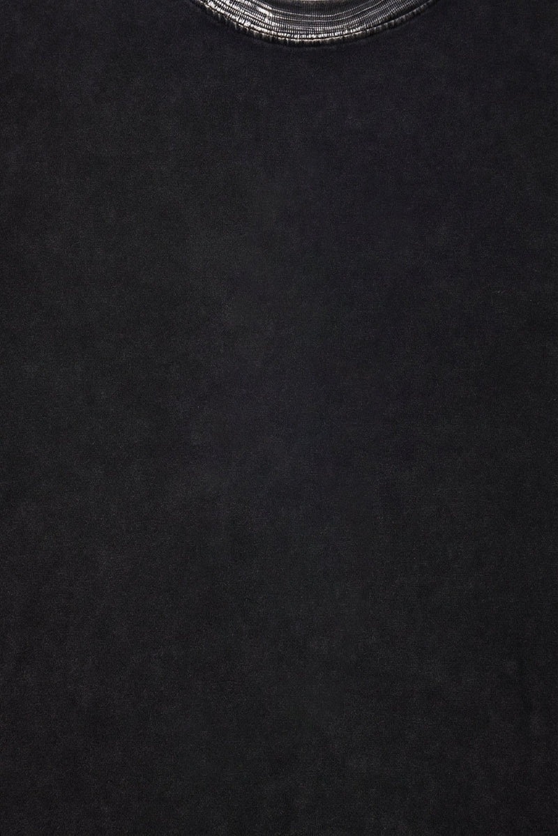 Close-up of a black washed cotton boxy T-shirt with a ribbed crew neck and relaxed streetwear fit