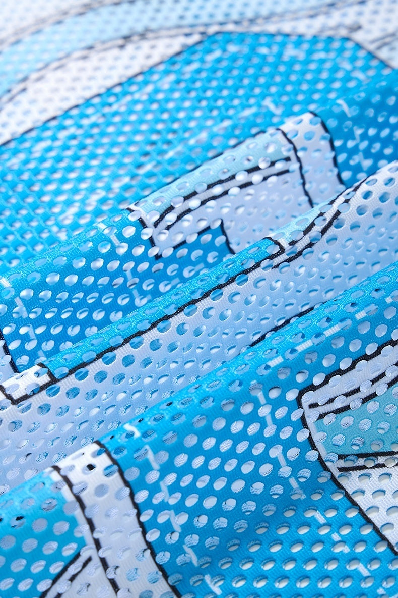 Close-up of blue mesh jersey fabric with white dotted pattern and black outlined graphic detailing
