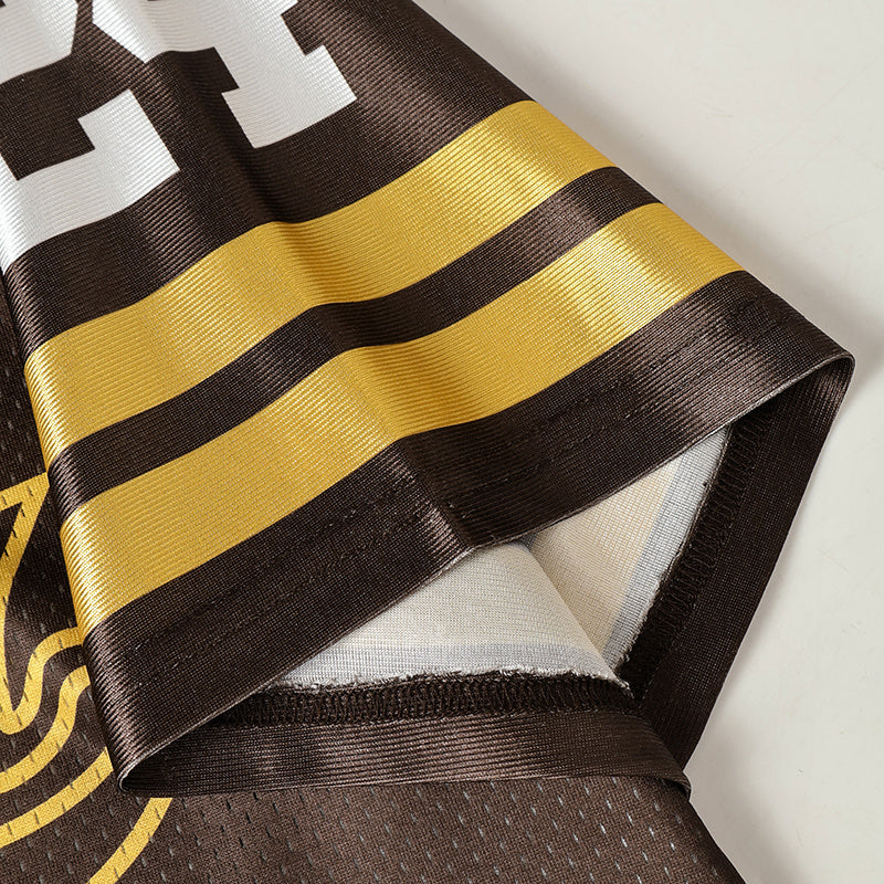 Close-up of a brown and gold varsity jersey sleeve with striped trim and flame graphic detailing