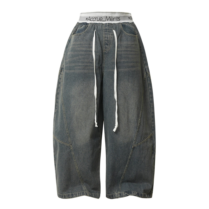 Front view of dark wash wide-leg denim pants with white drawstring waist and oversized fit