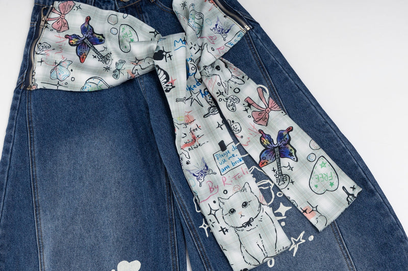 Top view of blue wide-leg jeans with printed ribbon bow tied across the front