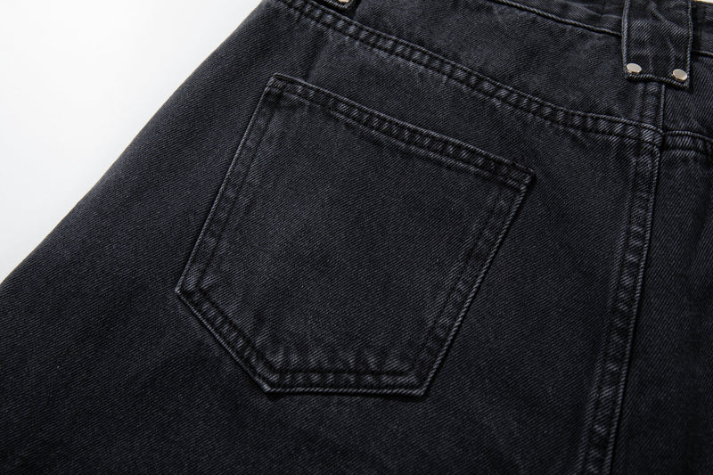 Close-up of the back pocket on washed black jeans with contrast stitching