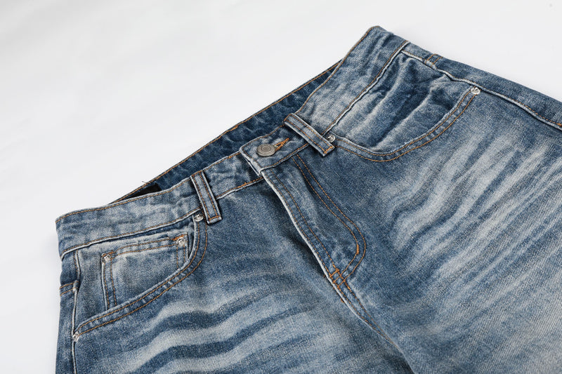 Close-up of front waistband and pocket on faded blue wide leg denim jeans
