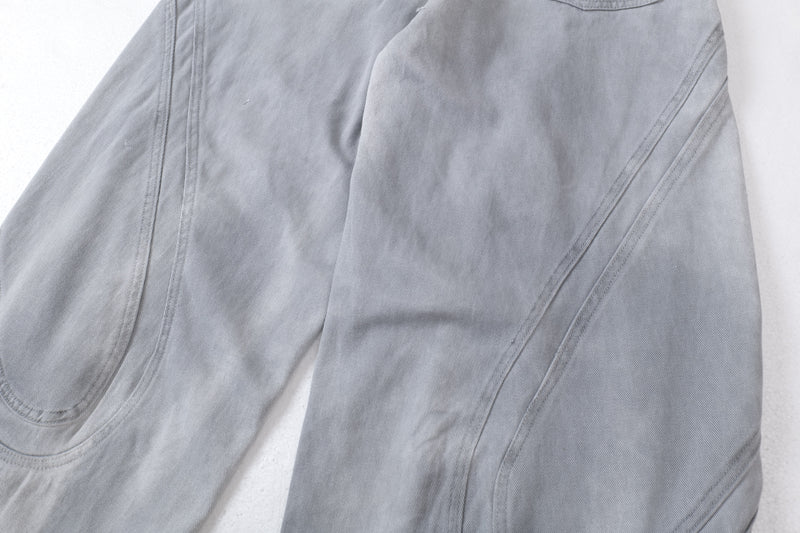 Close-up of the front leg panels and sculpted seam lines on light gray wide-leg jeans