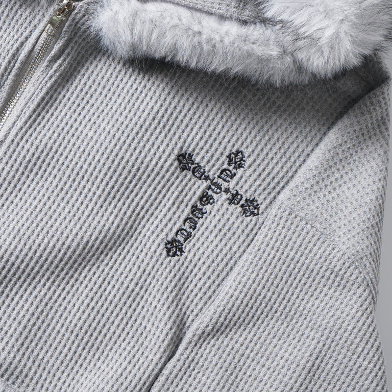 Close-up of the front chest area showing faux fur hood trim and black cross embroidery