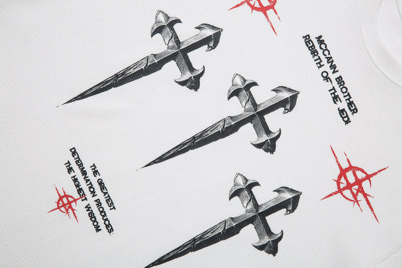 Diagonal close-up of black cross graphic and printed text on white tee