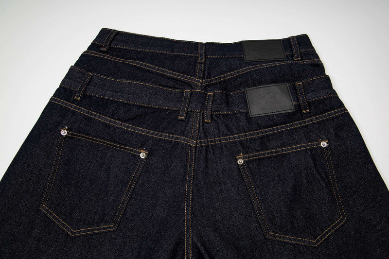 Back waistband and pockets of dark wash denim shorts with black label patches