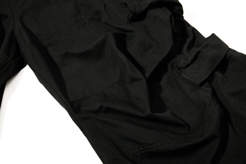 Close-up of black pants leg showing pocket seam and stitched paneling