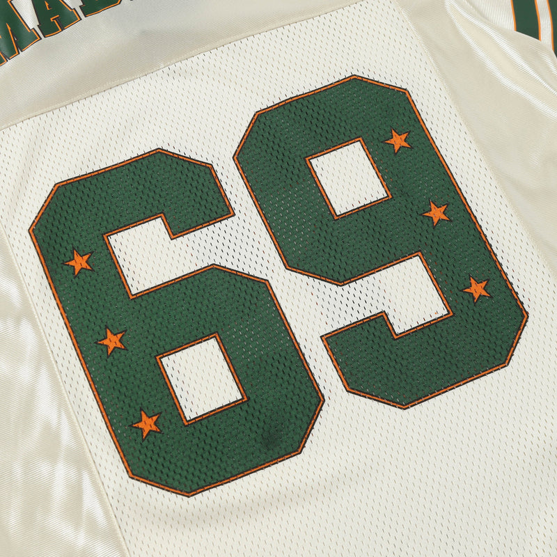 Close-up of a cream retro football jersey with green number 69 outlined in orange and star accents on mesh fabric