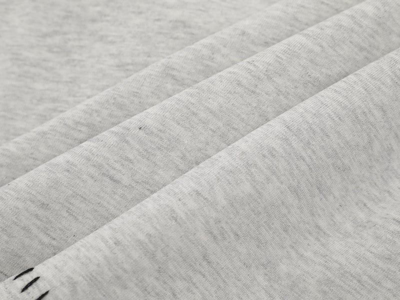 Close-up of heather gray fabric with soft heathered texture and folded sleeve layers