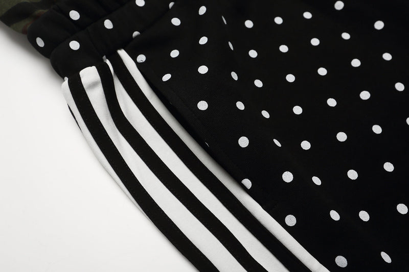 Side close-up of black shorts with white side stripes and polka dot fabric