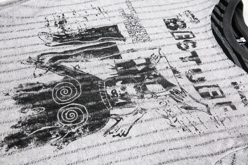Close-up of distressed graphic print on the gray sweater front