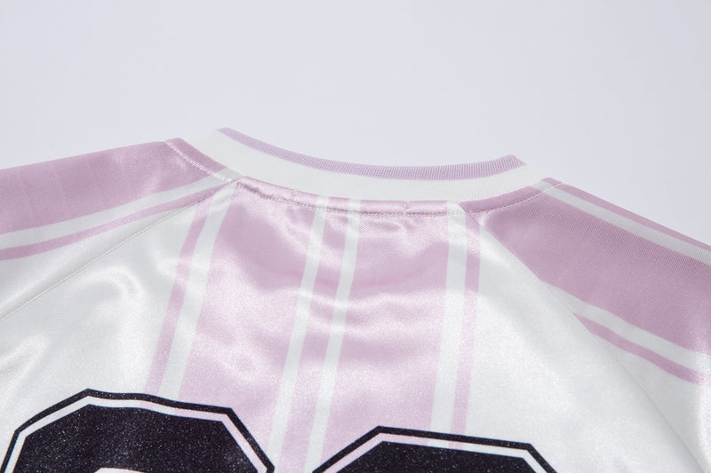 Close-up of the white jersey collar and upper shoulder seams with pink stripes