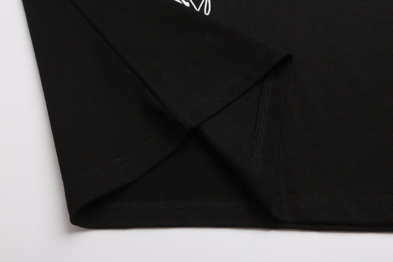 Black cotton raglan tee with folded hem and visible stitching, featuring white gothic script detail on the chest