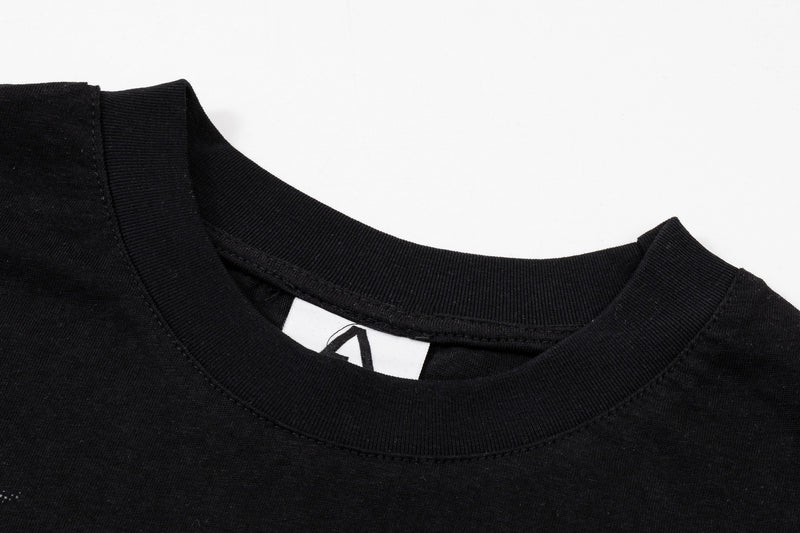 Black oversized graphic tee with ribbed crew neck and visible tag on a clean white background
