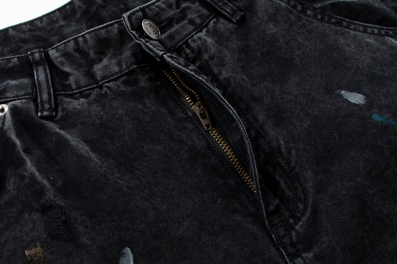 Close-up of black denim front waistband with zipper fly and button closure
