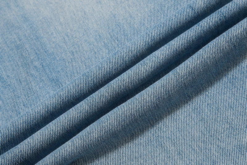 Close-up of light wash denim fabric folds and texture