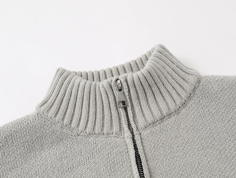 Close-up of light gray ribbed knit collar and top zipper on the cardigan