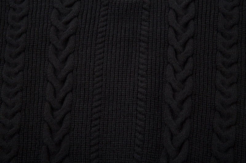Close-up of black cable knit sweater texture with dense braided pattern