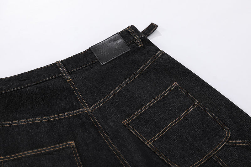 Close-up of black denim shorts back waistband, leather patch, and rear pocket