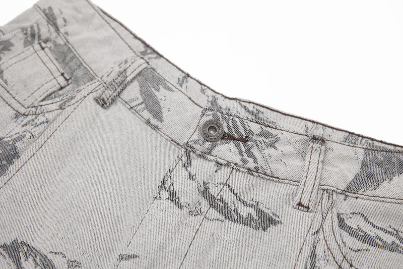 Close-up of the front waistband and button on gray brushstroke denim pants