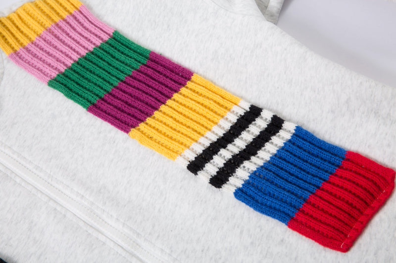 Close-up of a diagonal knitted scarf panel with pink, green, purple, yellow, black, blue, and red stripes