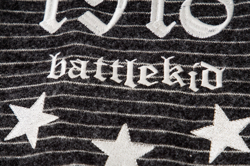 Close-up of black striped knit back graphic reading Battlekid