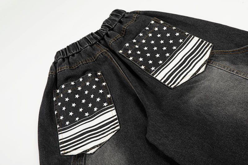 Close-up of back pockets on black washed denim pants with white star and stripe patches
