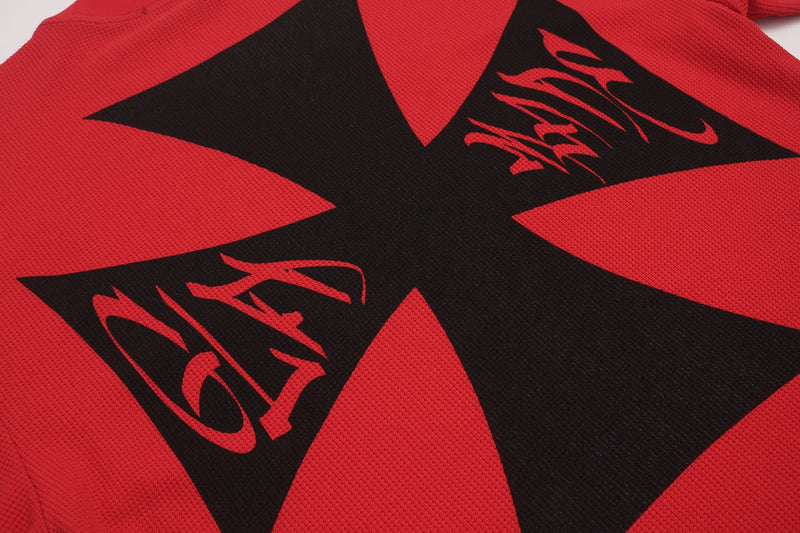 Red oversized graphic tee with bold black starburst design and edgy punk streetwear print
