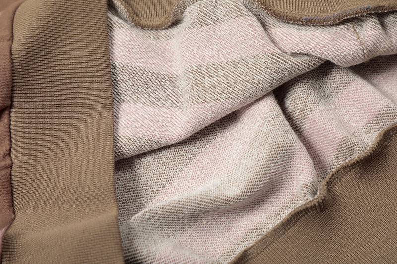 Close-up of inside hoodie lining and seam stitching in grey and pink fabric