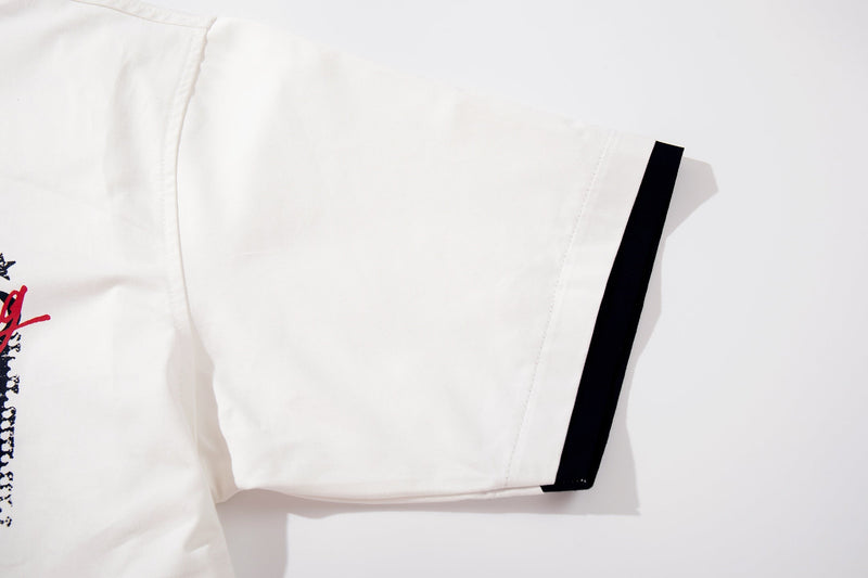 White oversized graphic T-shirt with black sleeve trim and partial bold print detail on the chest