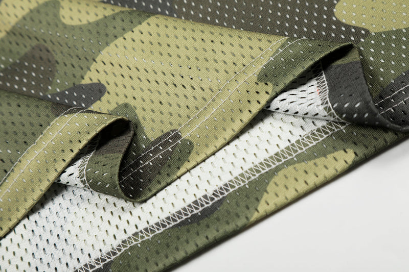 Close-up of olive and black camouflage mesh jersey fabric with visible stitching and breathable perforations
