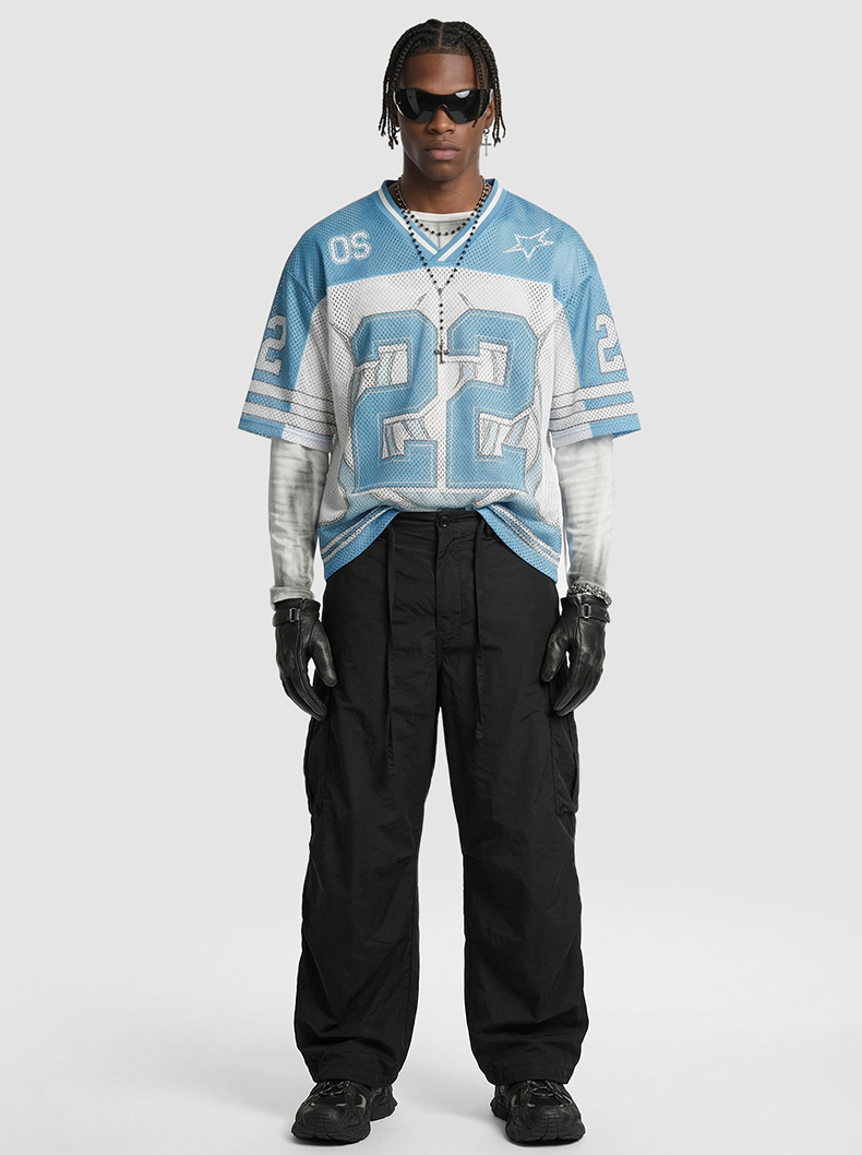 Model wearing a light blue mesh jersey T-shirt with oversized number 22, layered over a white long sleeve, and black cargo pants