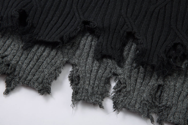 Close-up of black and charcoal gray distressed hems with frayed edges