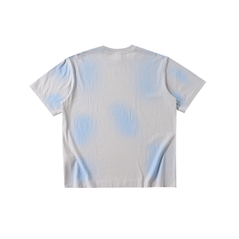 Light gray vintage spray-dyed short-sleeve tee with soft blue accents and a minimalist streetwear look