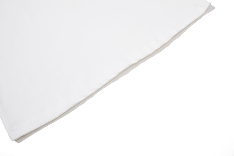 Close-up of a white cotton polo tee sleeve with clean stitched hem and smooth streetwear fabric texture
