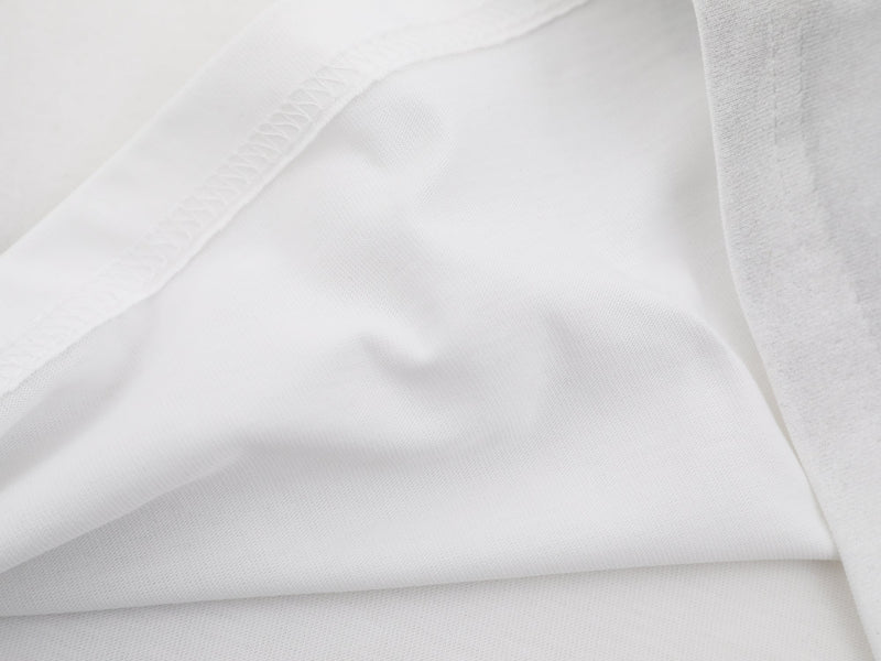 Close-up of white washed cotton tee fabric with visible stitching and soft textured folds