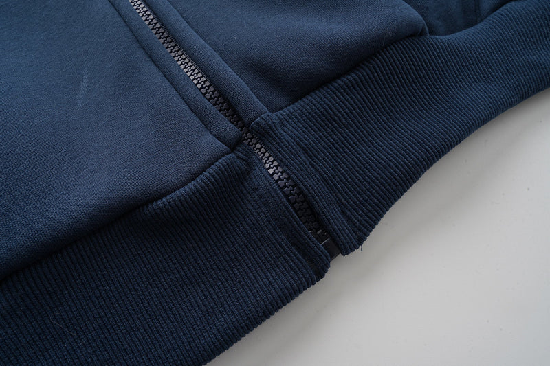 Close-up of navy zipper front and ribbed hem cuff