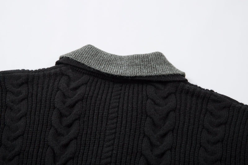Close-up of gray contrast collar on black cable knit polo sweater