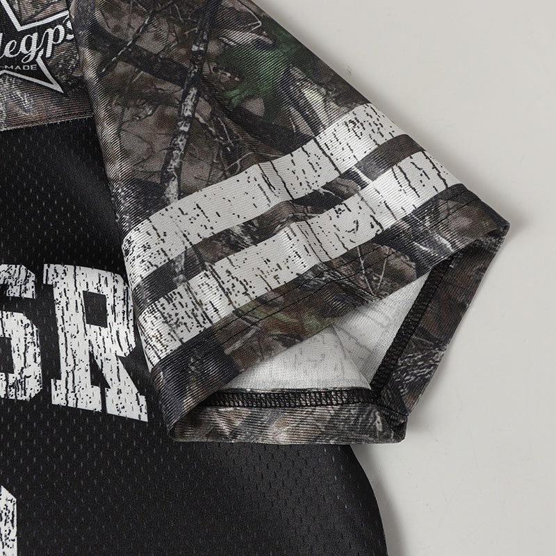Close-up of a camo football jersey sleeve with white striped trim and black mesh body on a plain background