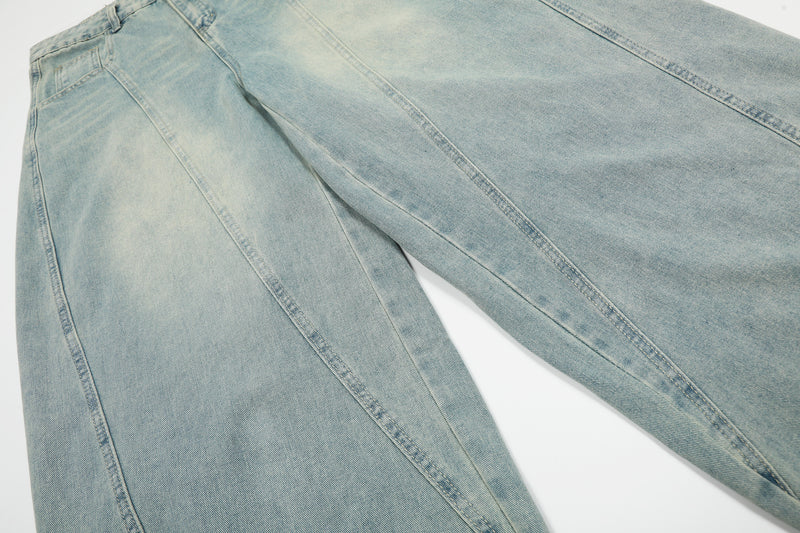 Close-up of wide leg denim panels on light wash barrel jeans