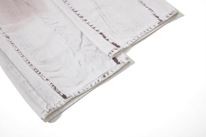 Close-up of hem corner on white washed denim pants with panel seam stitching