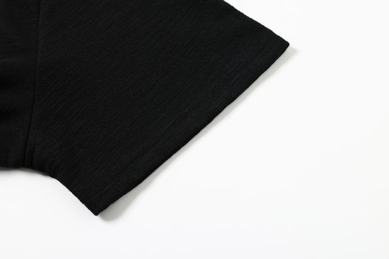 Black ribbed polo tee sleeve with subtle stripe texture on a clean white background